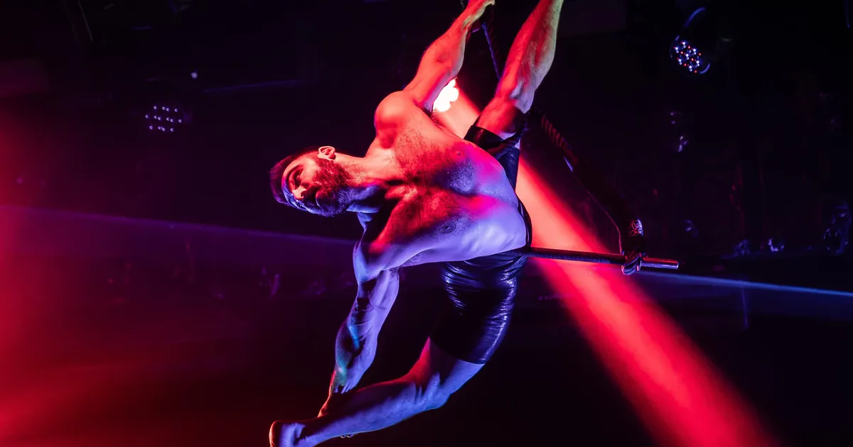 An aerial performer hangs from a hoop in red stage light at Dracula's on the Gold Coast