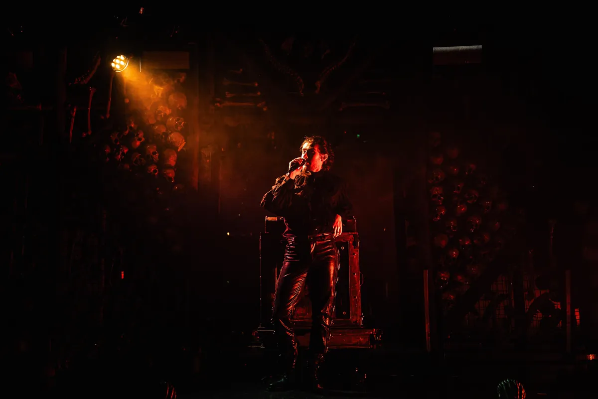 A singer in an amber spotlight on a dark gothic stage at Dracula's in Broadbeach